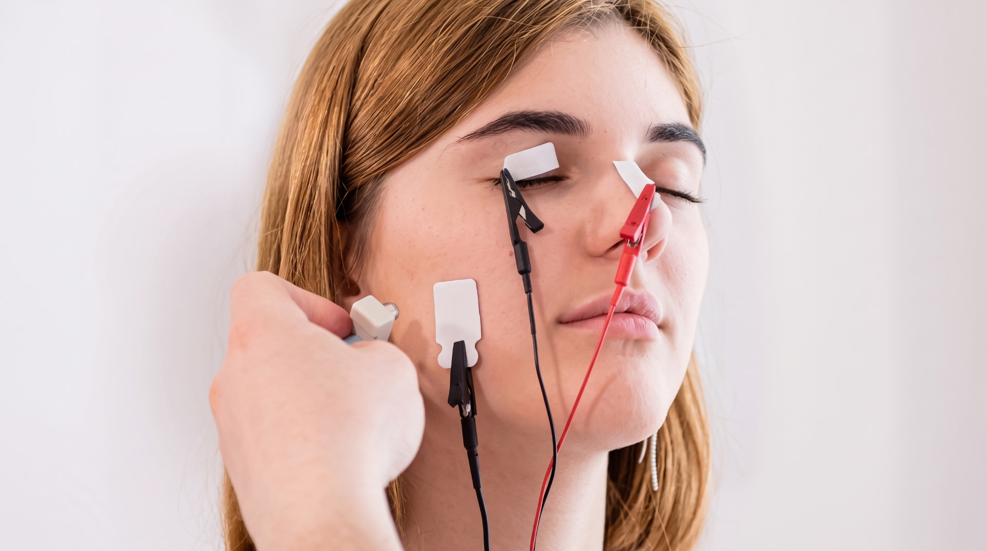 Electrodos de superficie colocados en el rostro de una persona durante una electromiografía facial